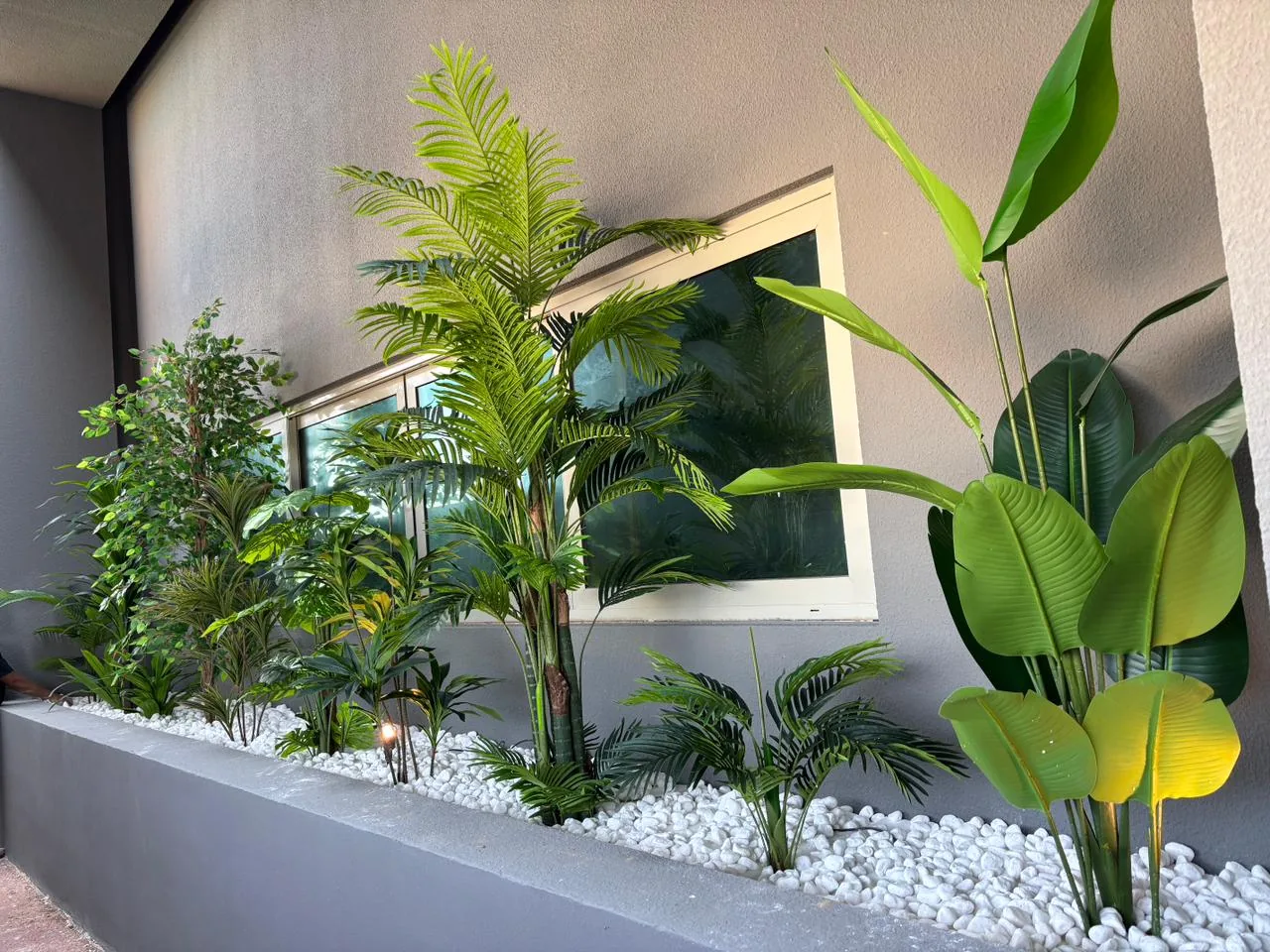 Real artificial greenery installation — palms and birds of paradise planter bed, Dubai